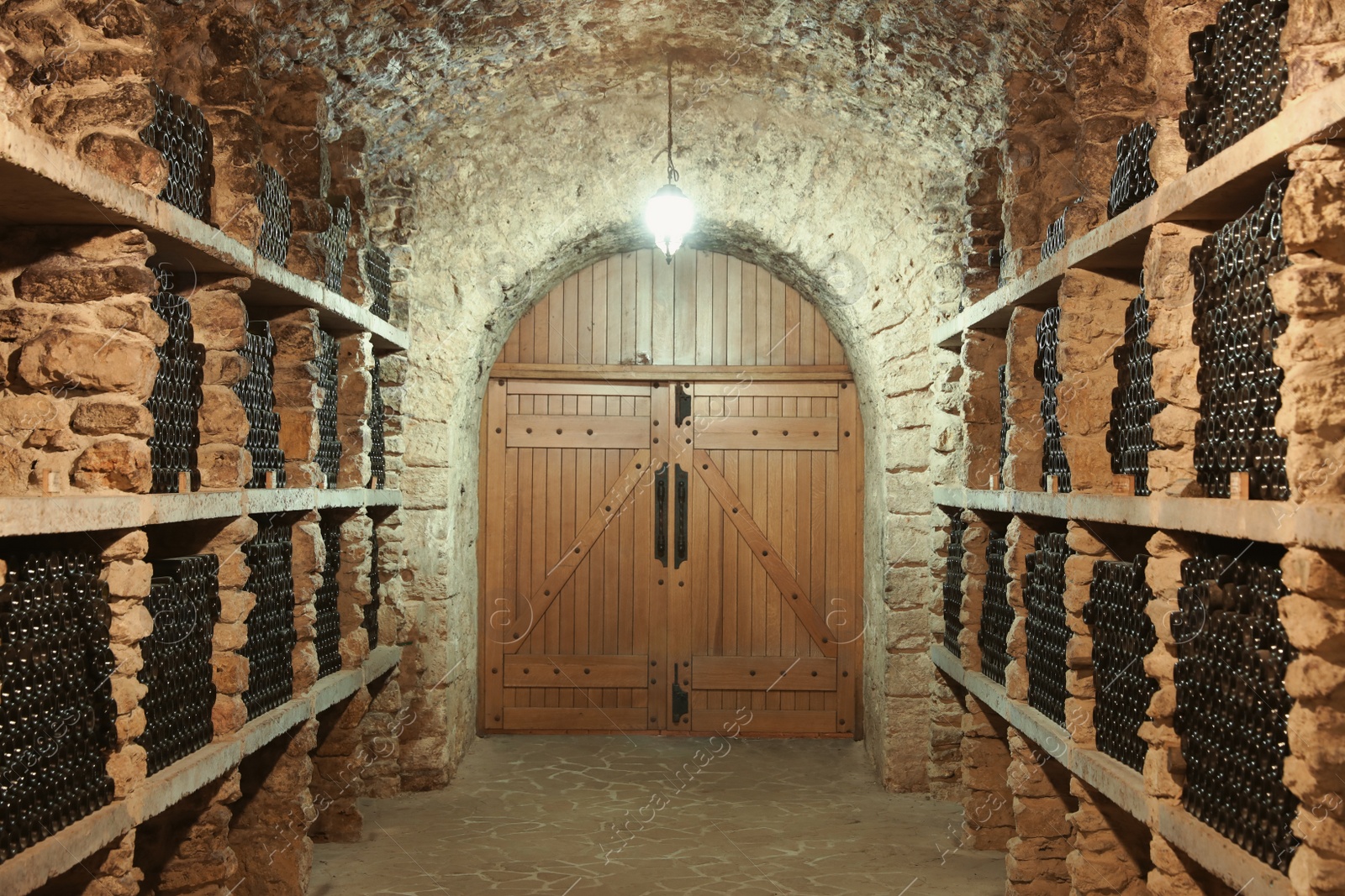 Photo of Wine cellar interior with many bottles on shelves