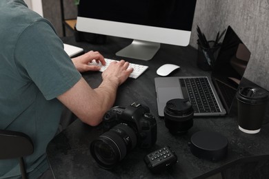 Photo of Photographer working on computer at dark table with camera, closeup