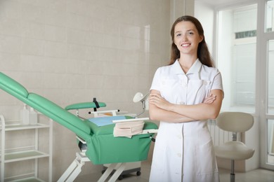 Portrait of smiling young gynecologist at workplace in clinic. Space for text