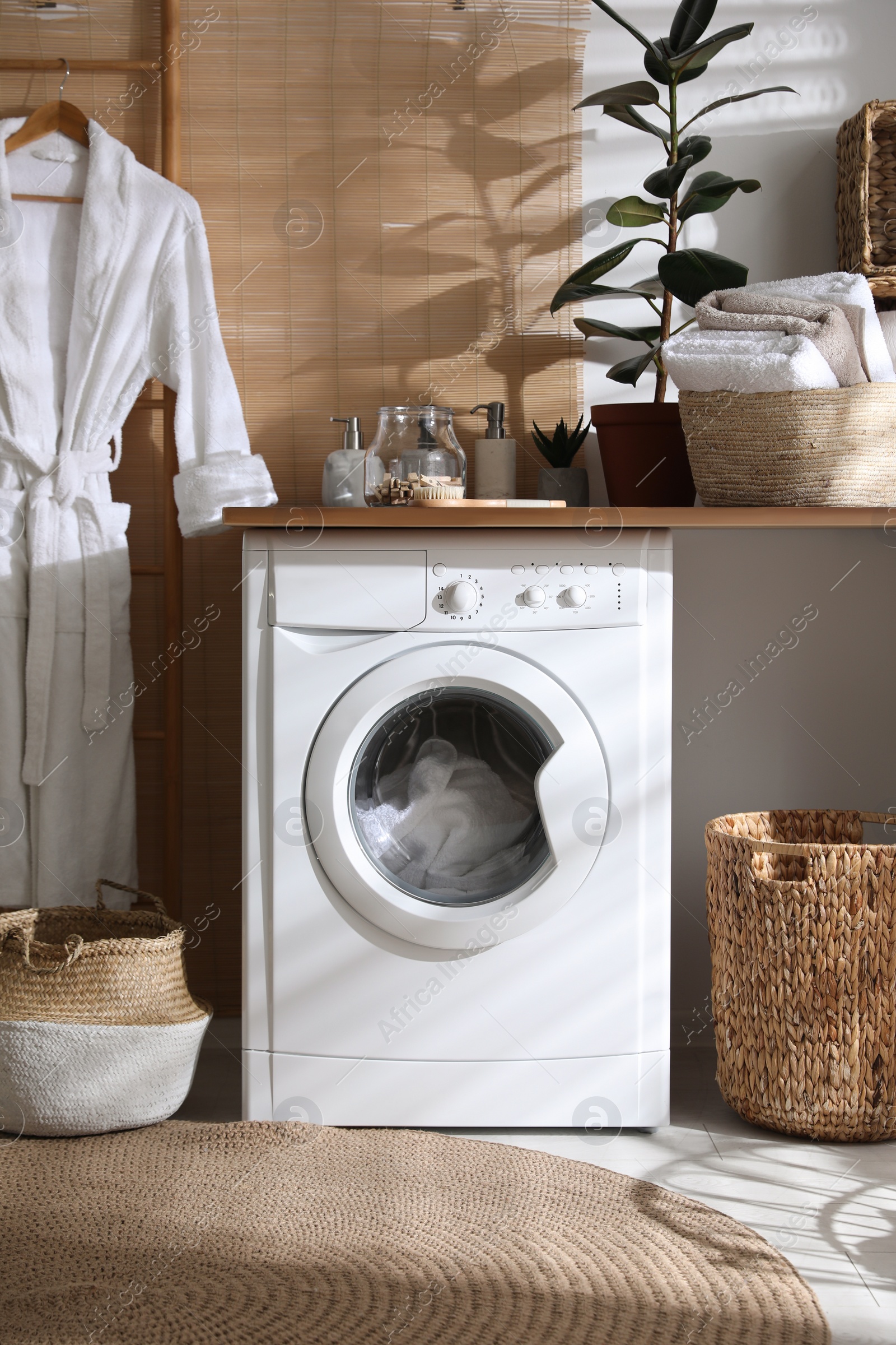 Photo of Stylish bathroom interior with modern washing machine