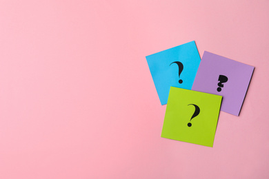Photo of Paper cards with question marks on pink background, flat lay. Space for text