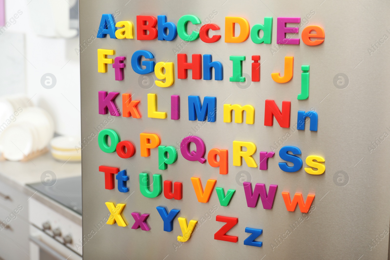 Photo of Colorful magnetic letters on refrigerator door indoors