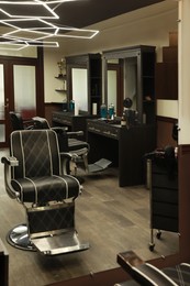 Photo of Stylish hairdresser's workplace with professional armchair in barbershop