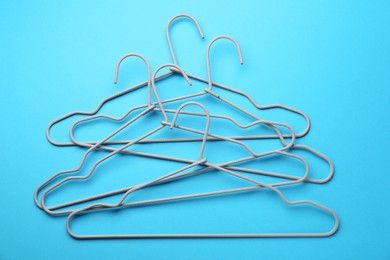 Hangers on light blue background, top view
