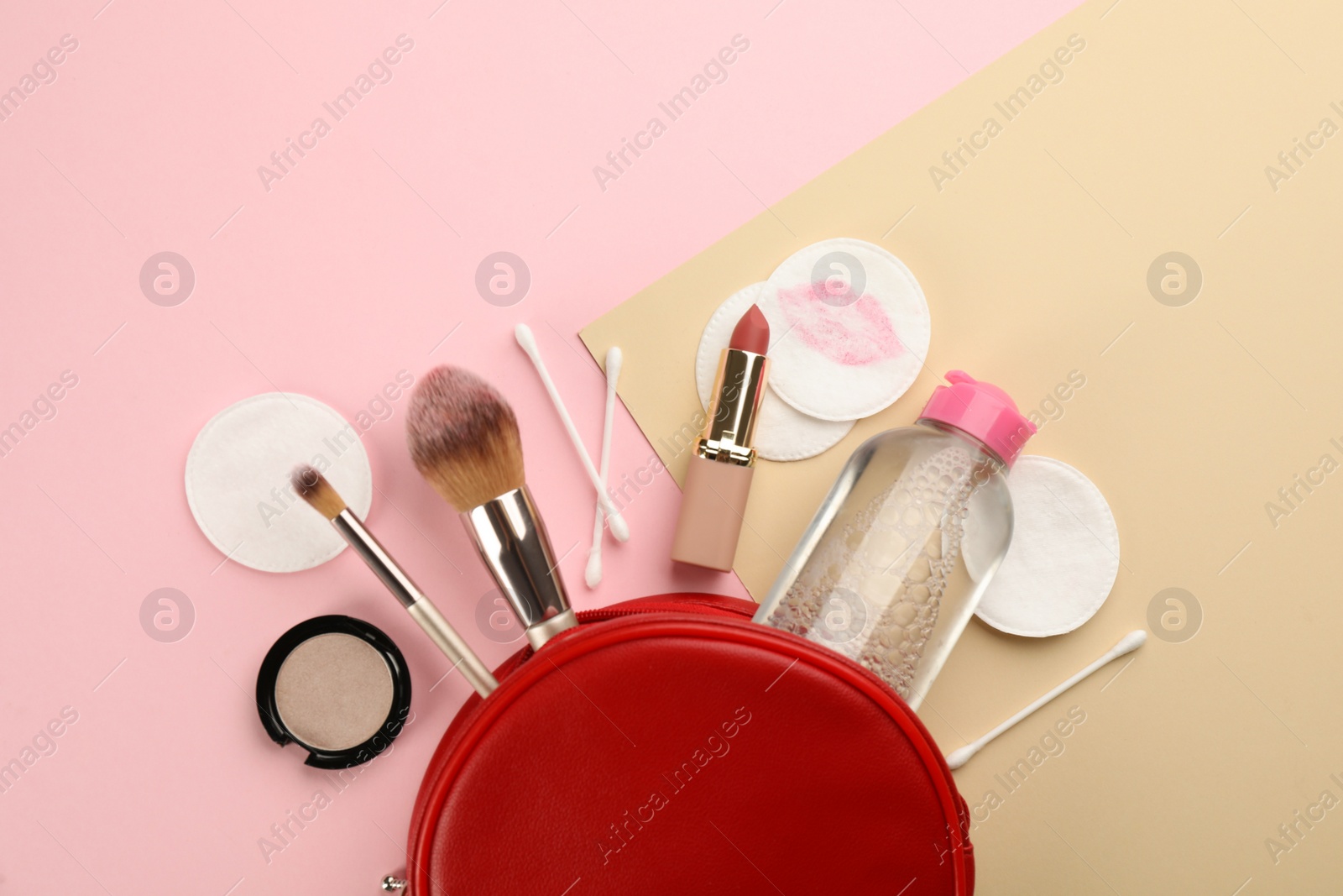 Photo of Dirty cotton pads, swabs, cosmetic products and micellar cleansing water on color background, flat lay