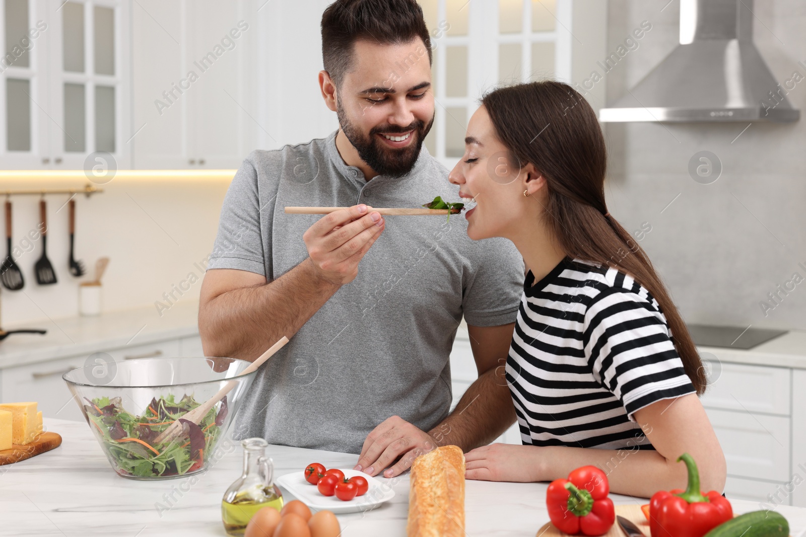 Photo of Lovely young couple cooking together in kitchen