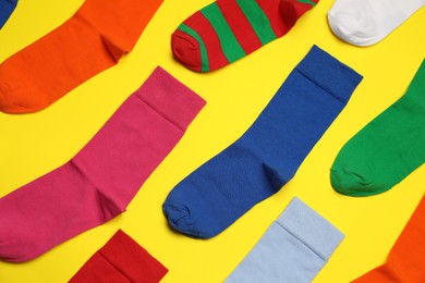 Photo of Flat lay composition of different colorful socks on yellow background