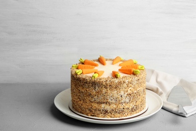 Dish with delicious carrot cake on table against wooden background. Space for text