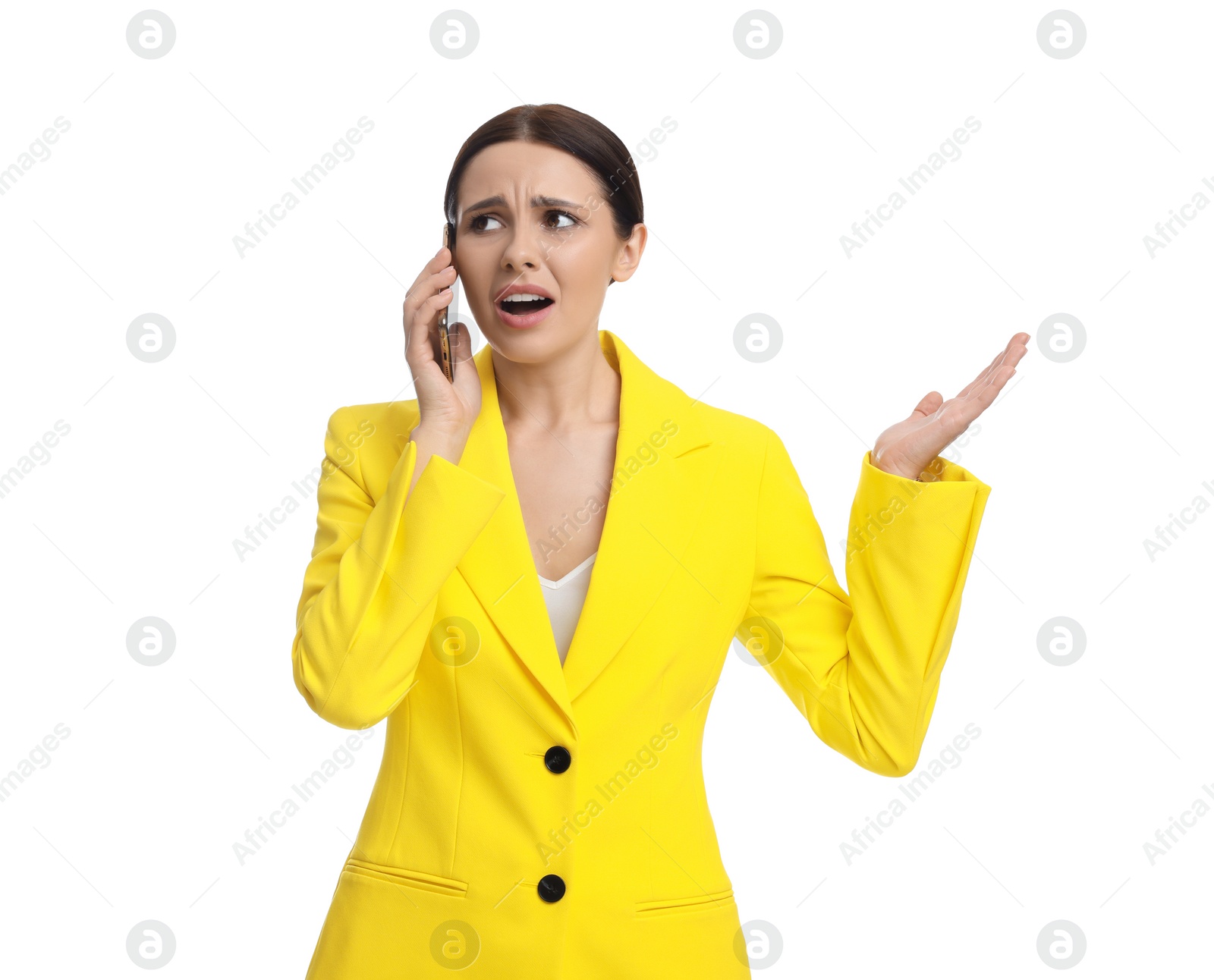 Photo of Beautiful emotional businesswoman in yellow suit talking on smartphone against white background