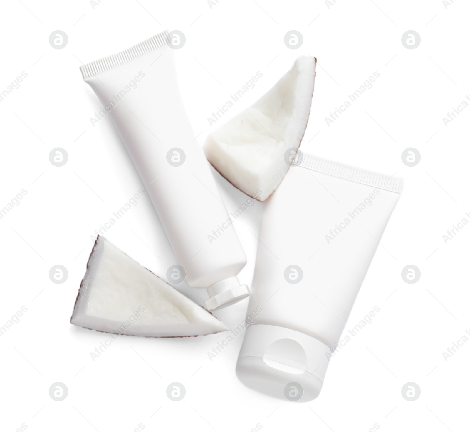 Photo of Tubes of hand cream and coconut pieces on white background, top view