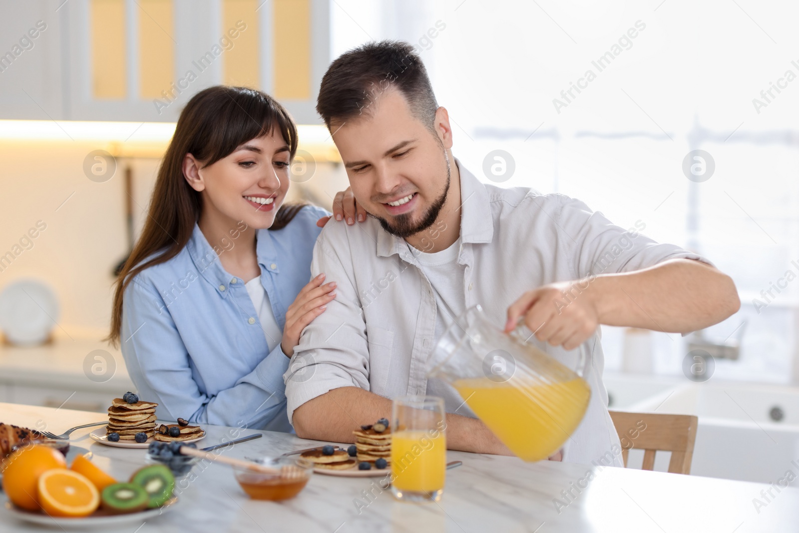 Photo of Happy couple having tasty breakfast at home