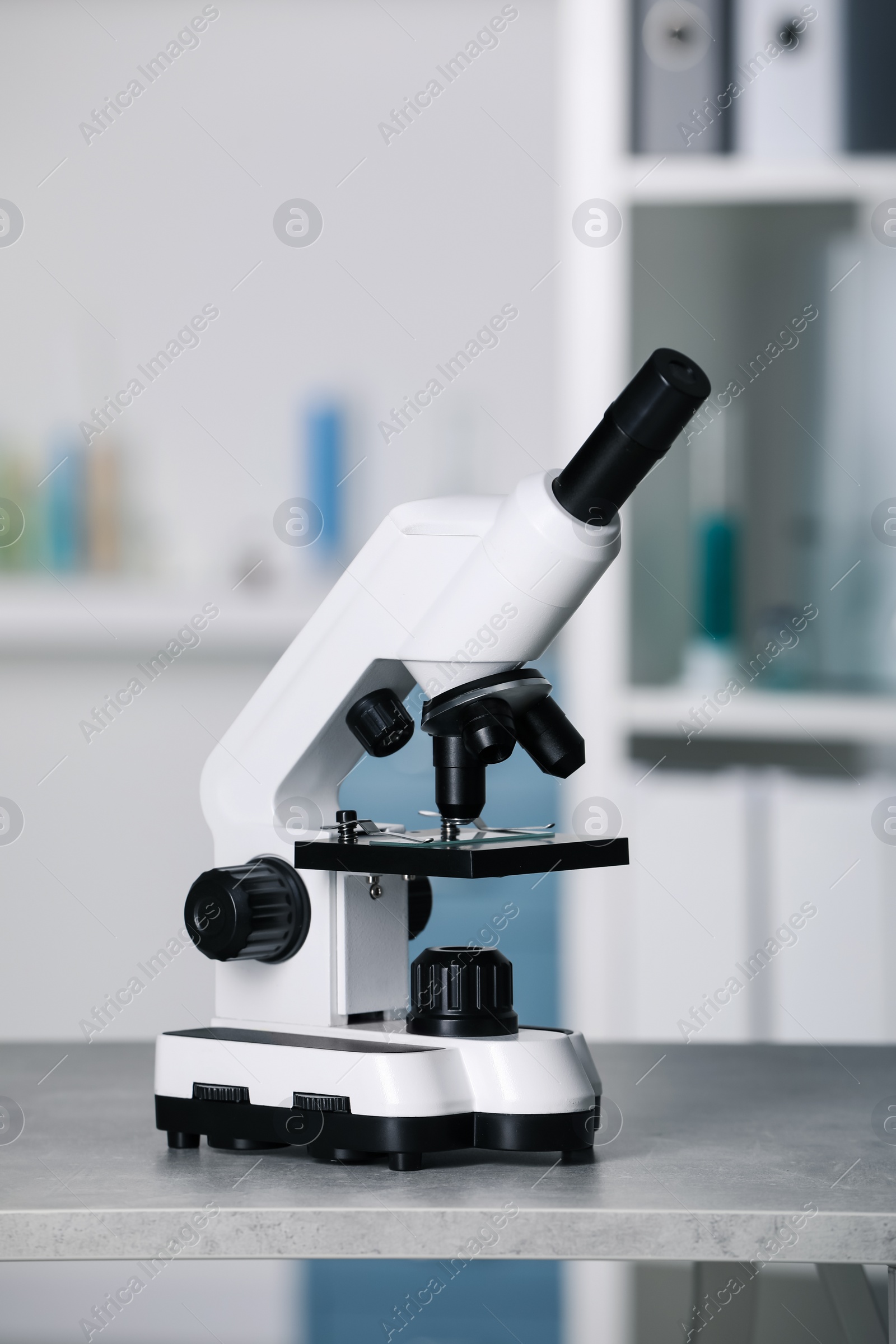 Photo of Modern medical microscope on grey table in laboratory