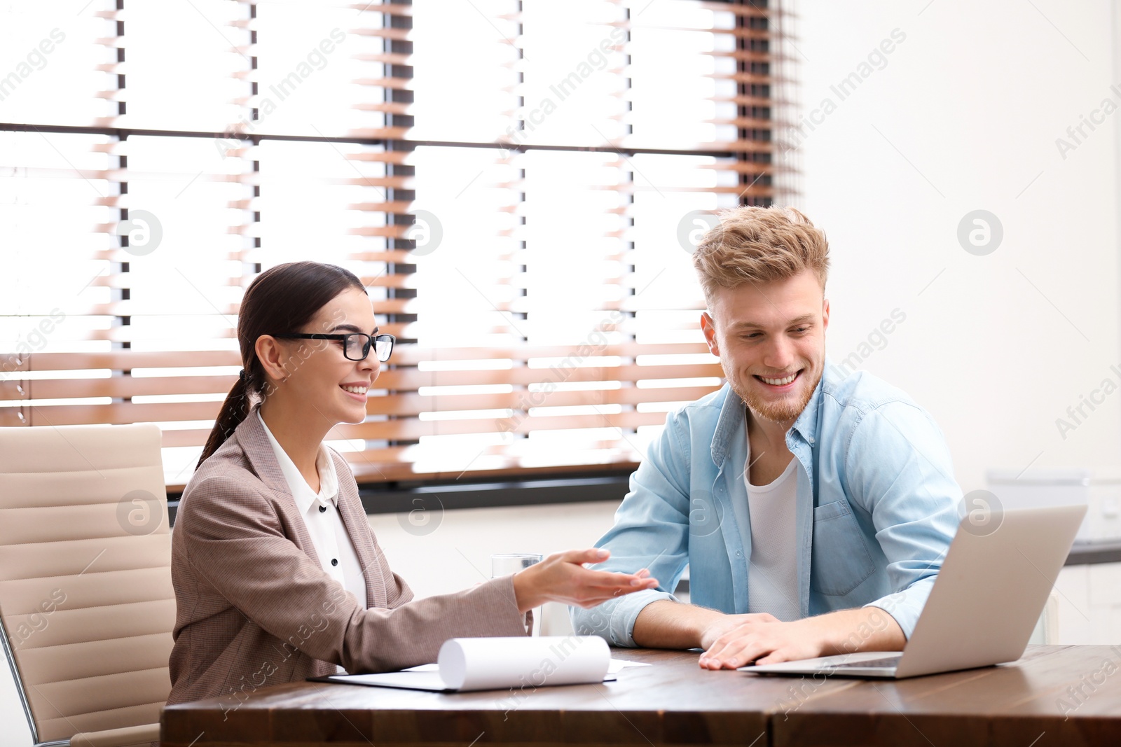 Photo of Female insurance agent consulting young man in office