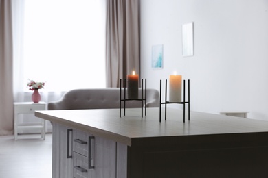 Photo of Burning candles on table in living room