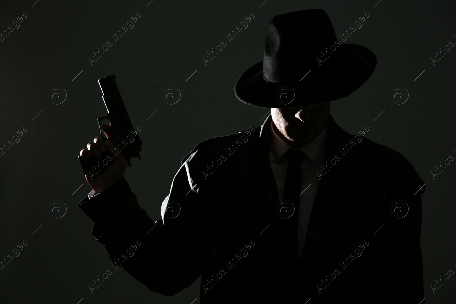 Photo of Old fashioned detective with gun on dark background