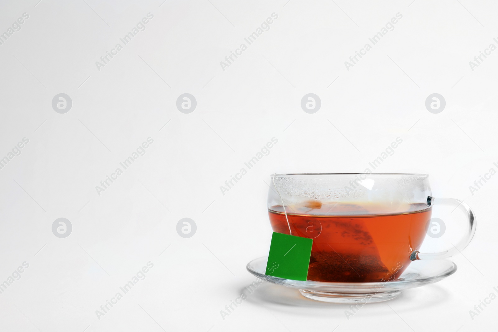 Photo of Hot tea in glass cup on white background