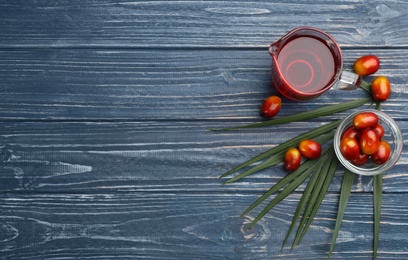 Photo of Flat lay composition with palm oil, tropical leaf and fresh fruits on blue wooden table. Space for text