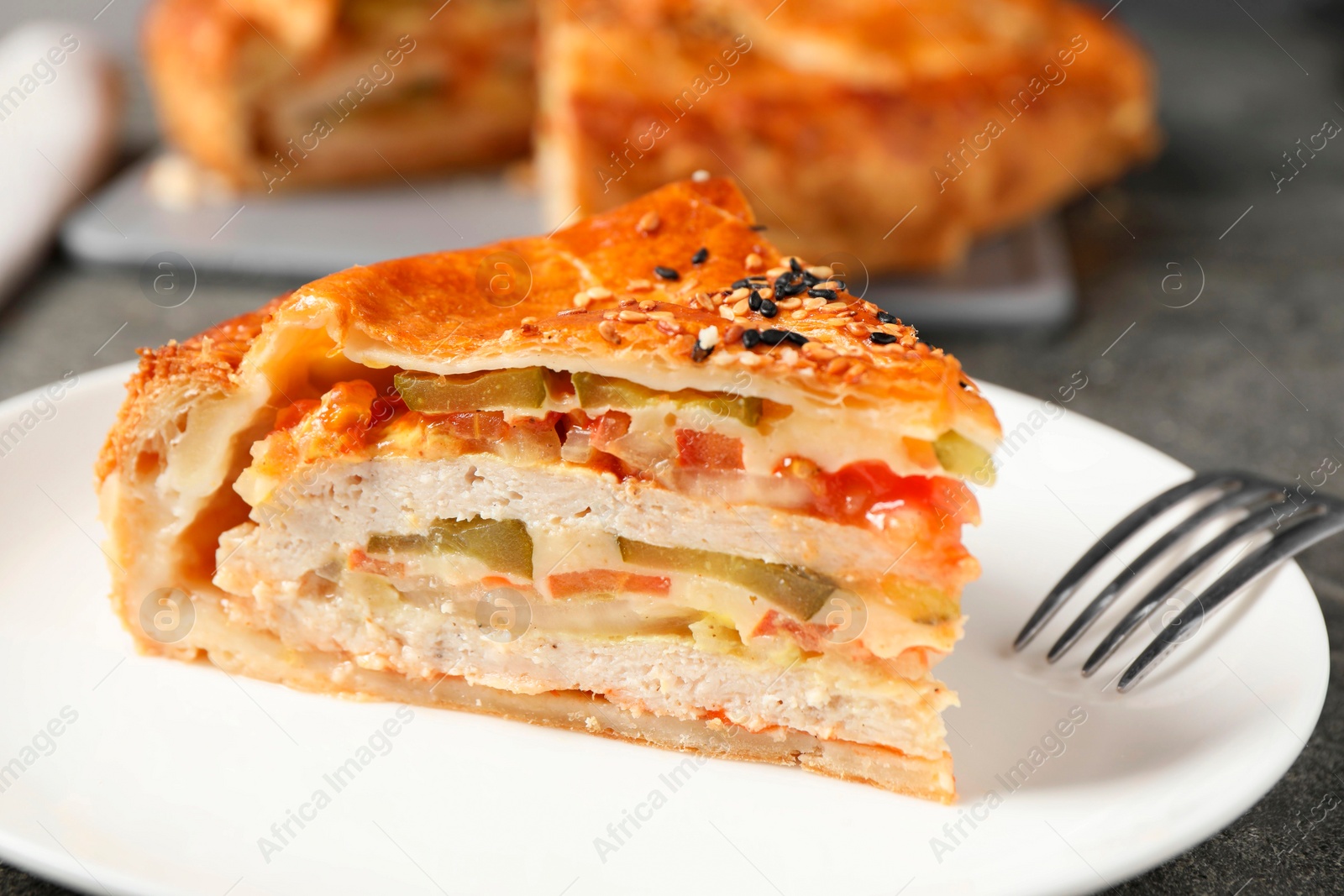 Photo of Piece of tasty homemade pie with filling served on grey table, closeup