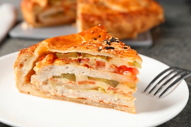 Piece of tasty homemade pie with filling served on grey table, closeup