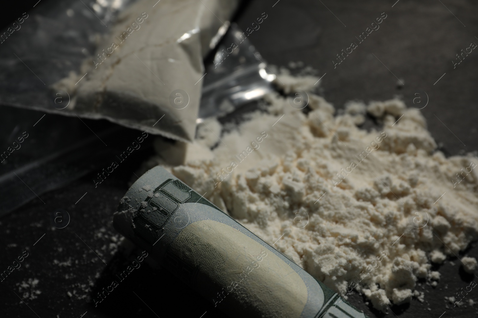 Photo of Drug addiction. Cocaine and rolled dollar banknote on grey table, closeup