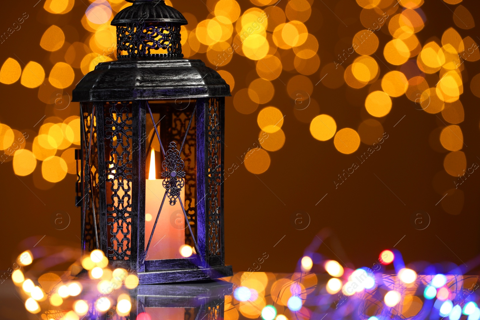 Photo of Arabic lantern on mirror surface against blurred lights, space for text