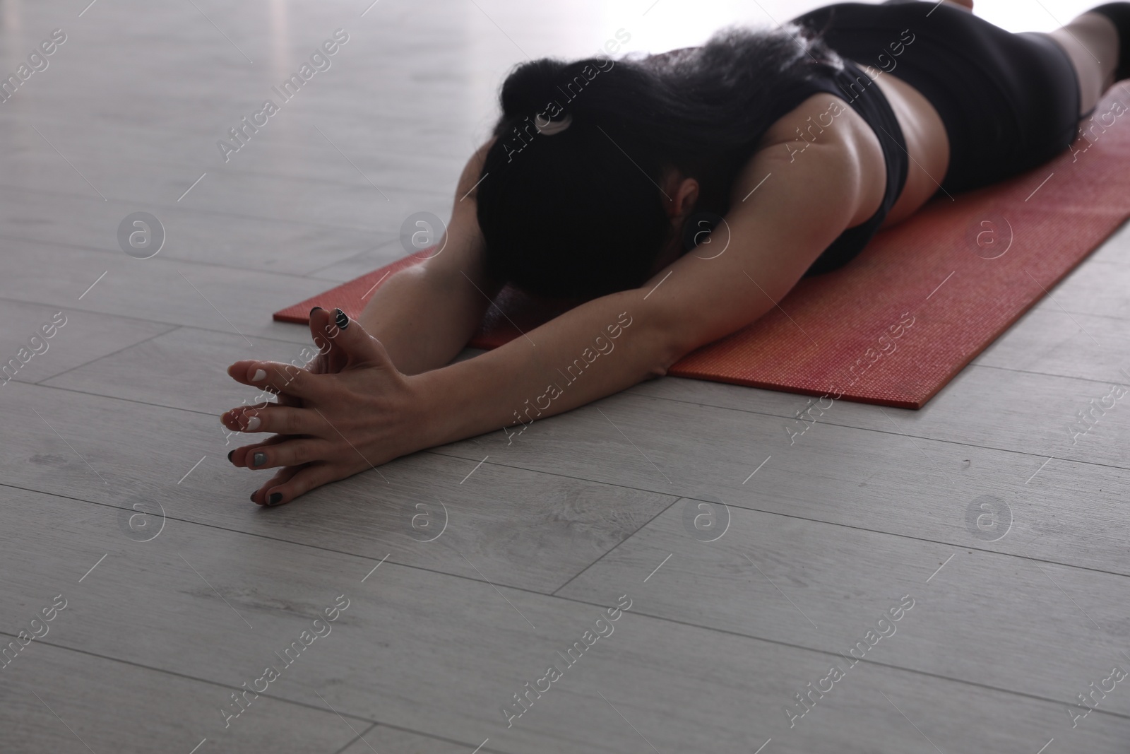 Photo of Young woman practicing relaxation pose in yoga studio, closeup