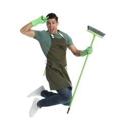 Photo of Man with green broom jumping on white background