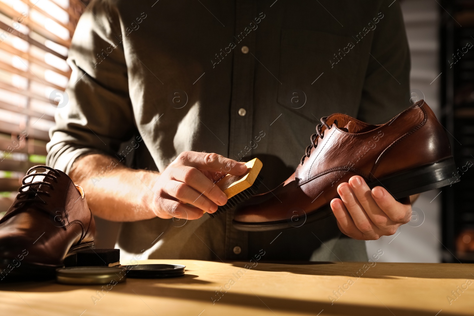 Photo of Master taking care of shoes in his workshop, closeup