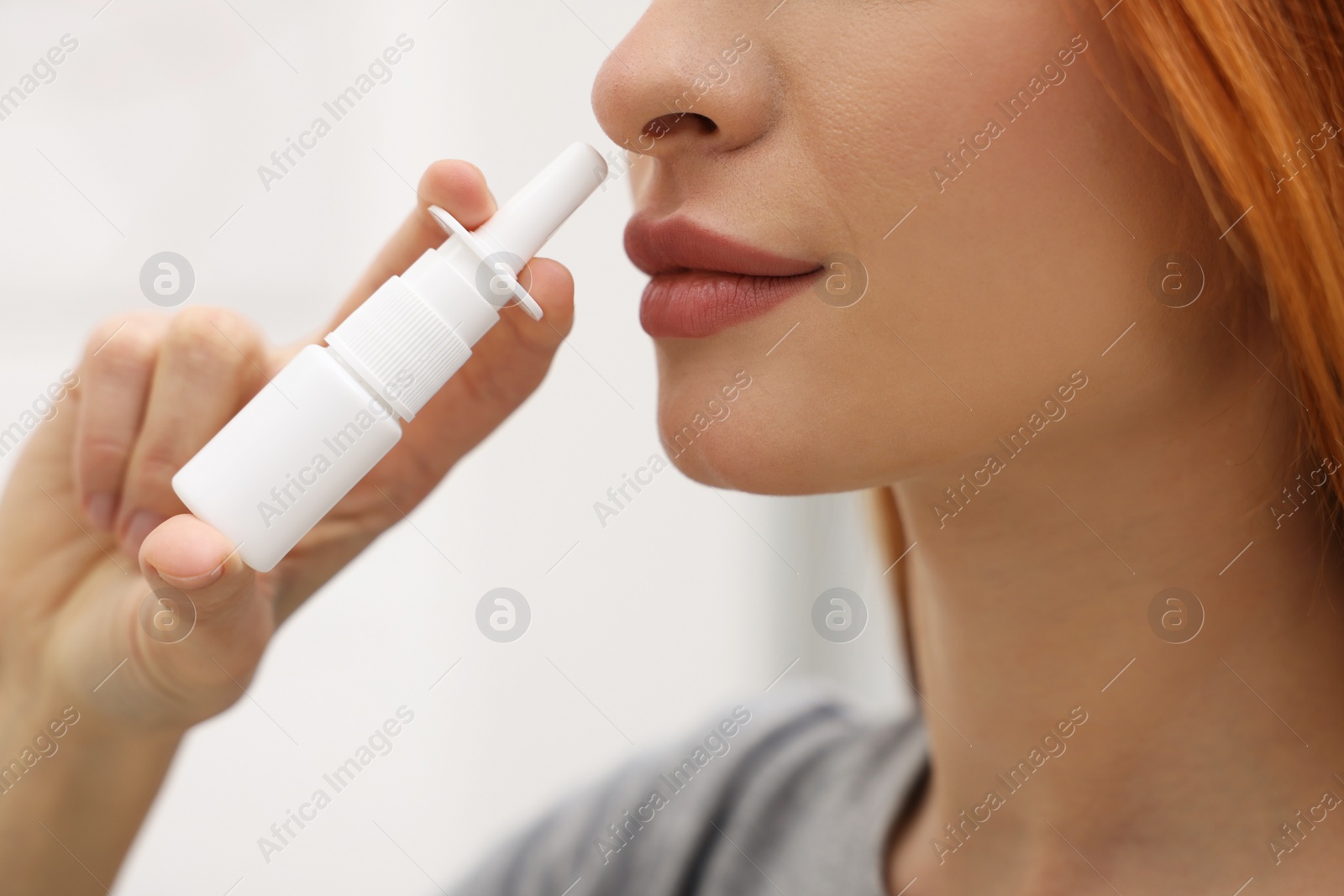Photo of Medical drops. Woman using nasal spray at home, closeup
