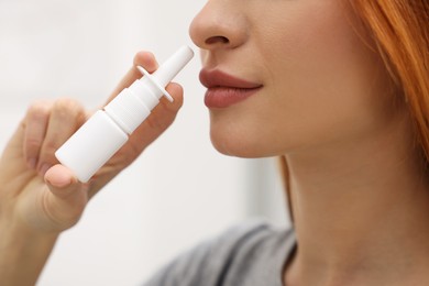 Photo of Medical drops. Woman using nasal spray at home, closeup