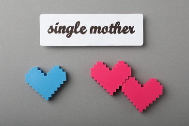 Photo of Hearts and text Single mother on grey background, flat lay