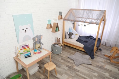 Photo of Cute child's room interior with toys and modern furniture