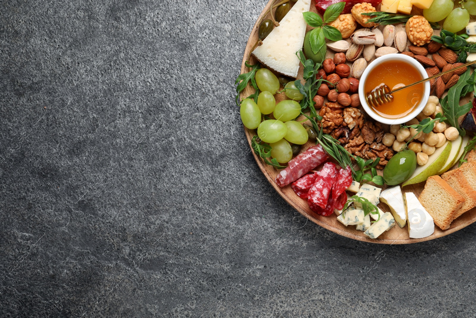 Photo of Different tasty appetizers on dark grey table, top view. Space for text