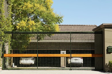 Photo of Security metal gates near trees and estate outdoors