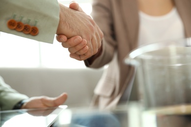 Photo of Business partners shaking hands after meeting, closeup