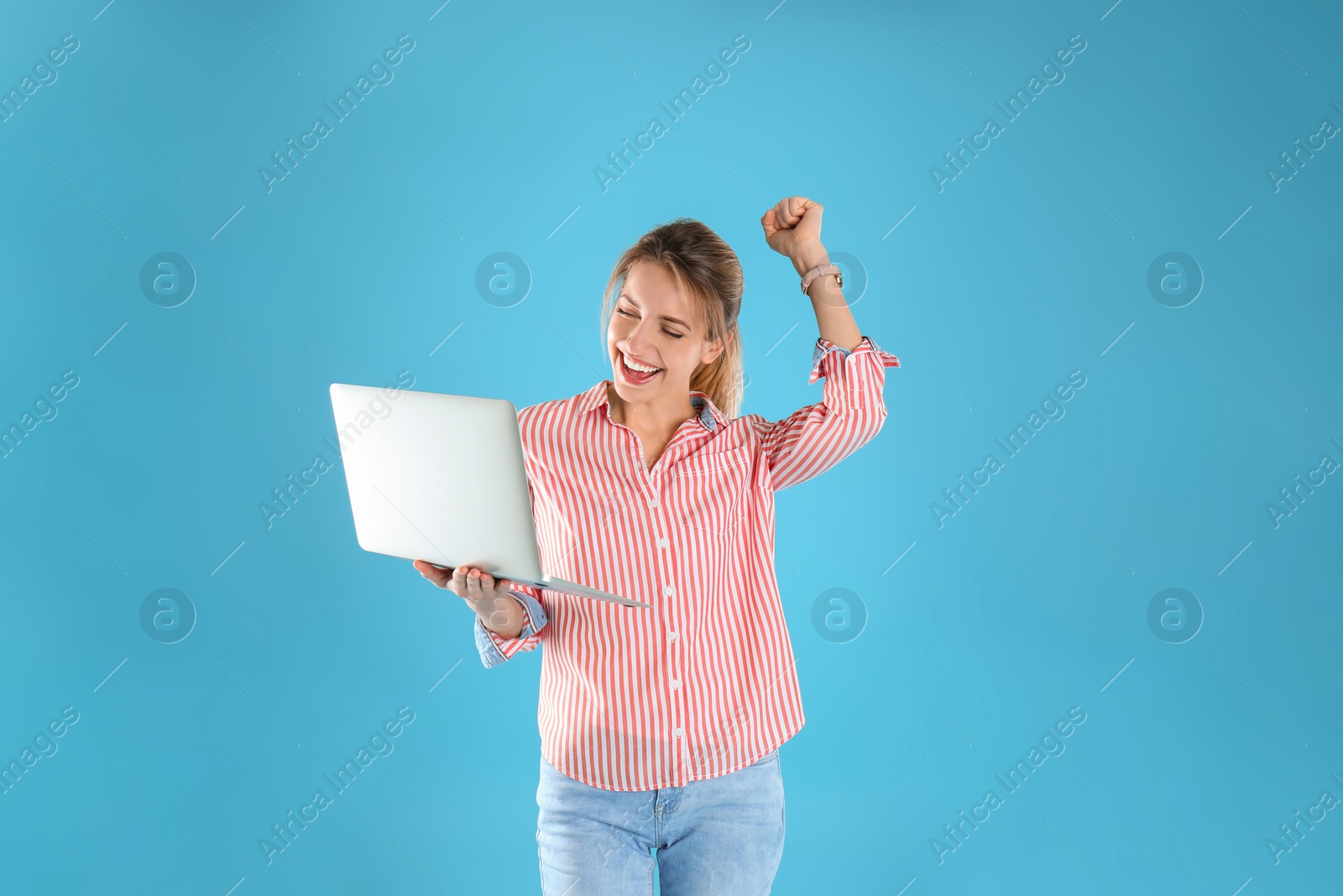 Photo of Portrait of happy young woman in casual outfit with laptop on color background