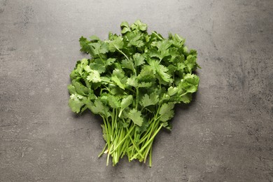 Photo of Bunch of fresh green cilantro on grey table, top view