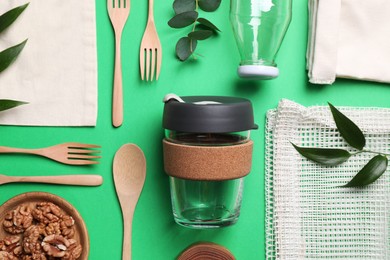 Photo of Flat lay composition with eco friendly products on green background
