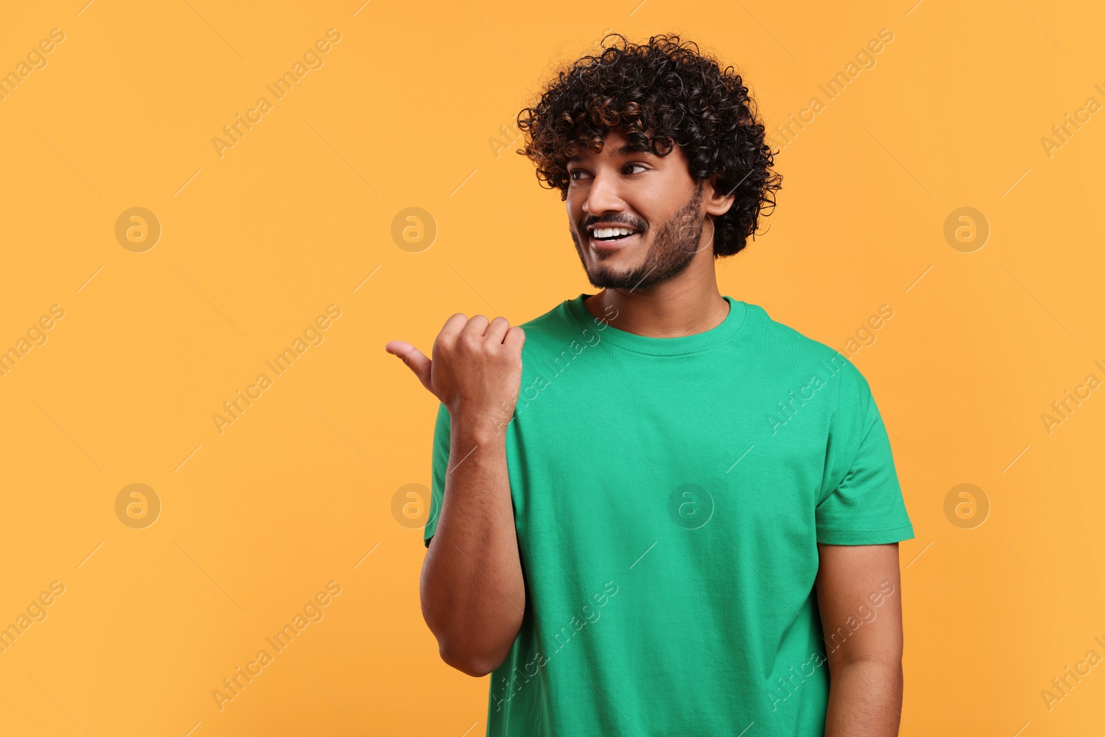 Photo of Handsome smiling man on yellow background, space for text