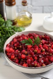 Photo of Bowl of delicious fresh vinaigrette salad on white wooden table, closeup