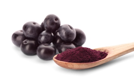 Wooden spoon with acai powder and berries on white background