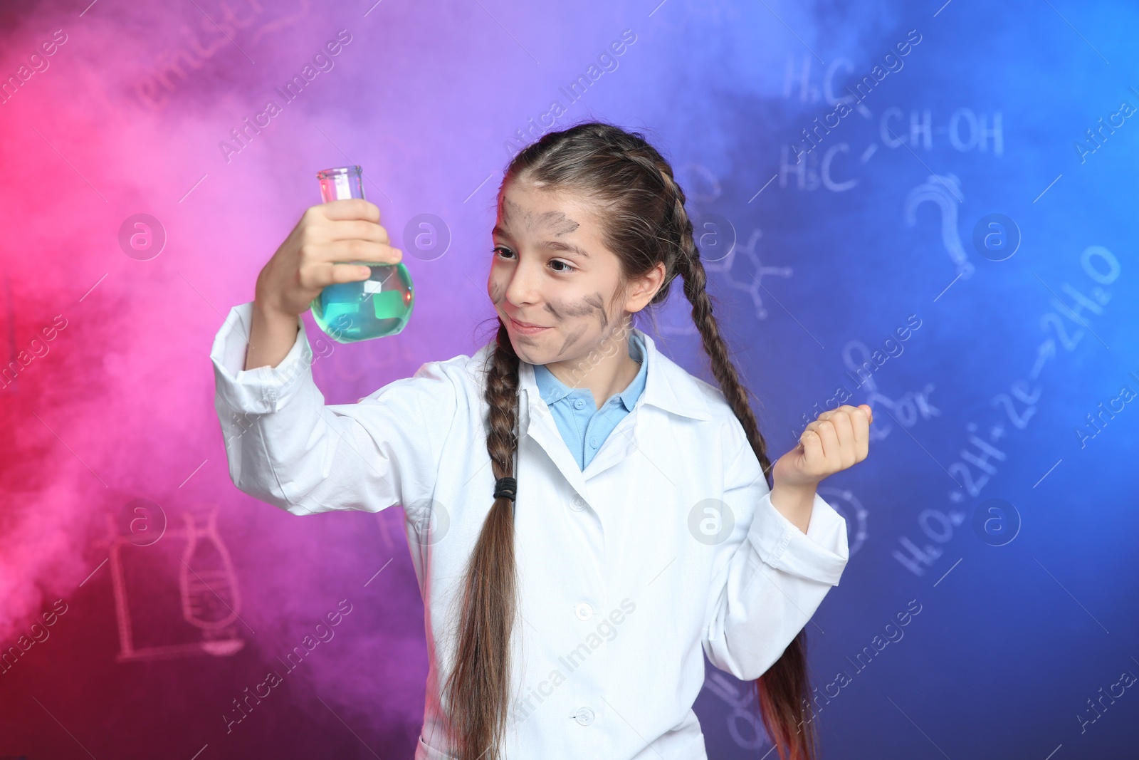 Photo of Emotional pupil holding Florence flask in smoke against blackboard with chemistry formulas