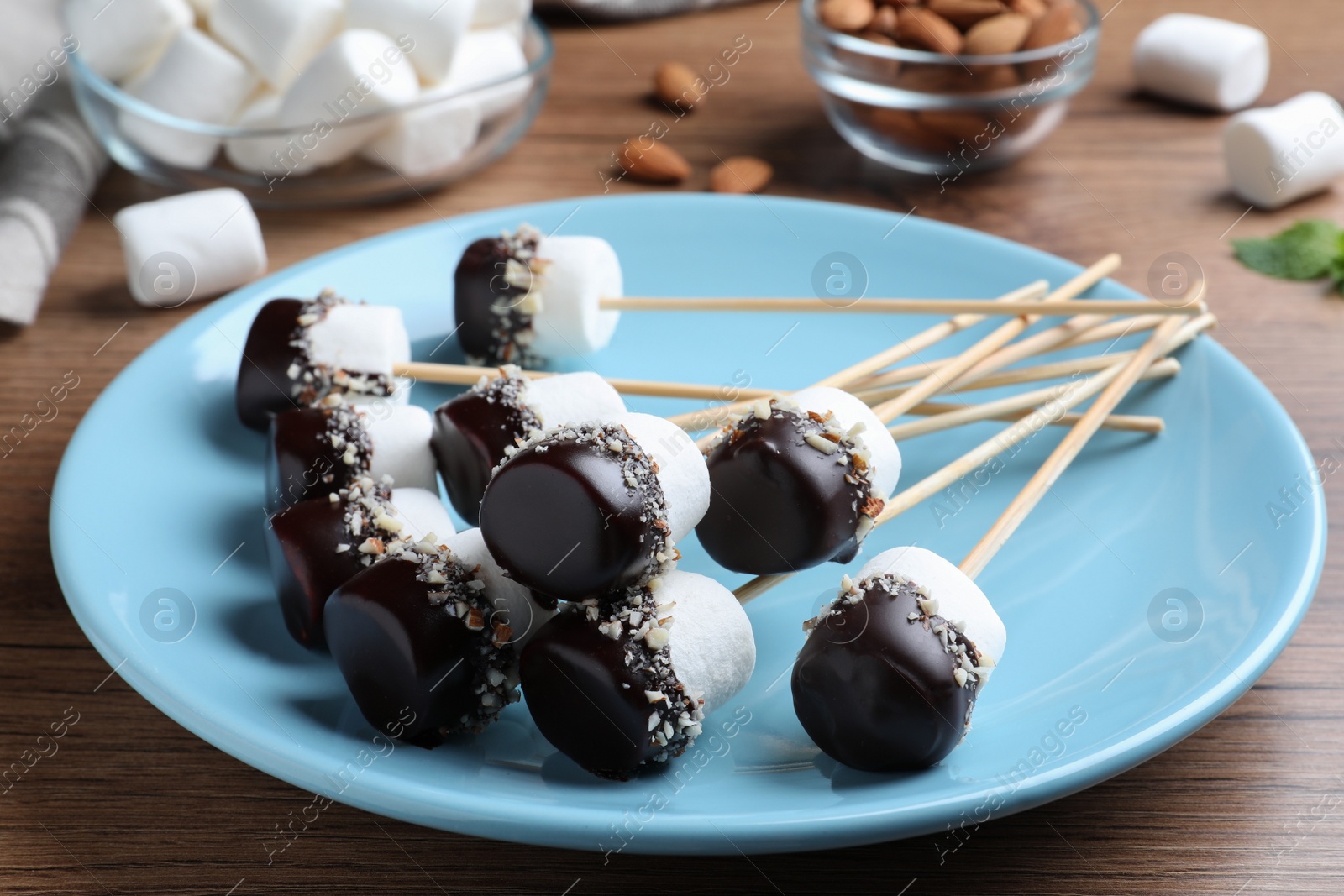 Photo of Delicious marshmallows covered with chocolate on wooden table