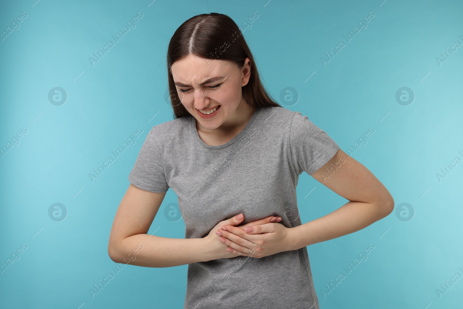 Photo of Woman having heart attack on light blue background