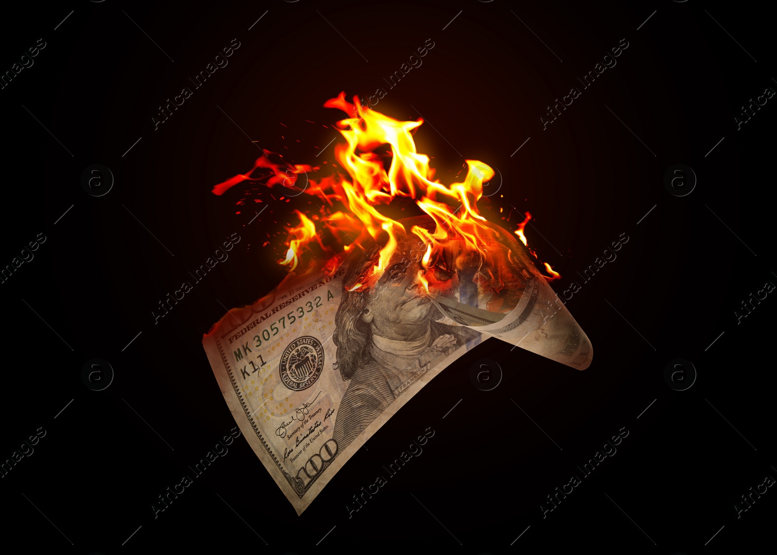 Image of One hundred dollar banknote burning on black background