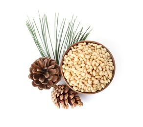 Photo of Bowl with pine nuts and cones on white background, top view