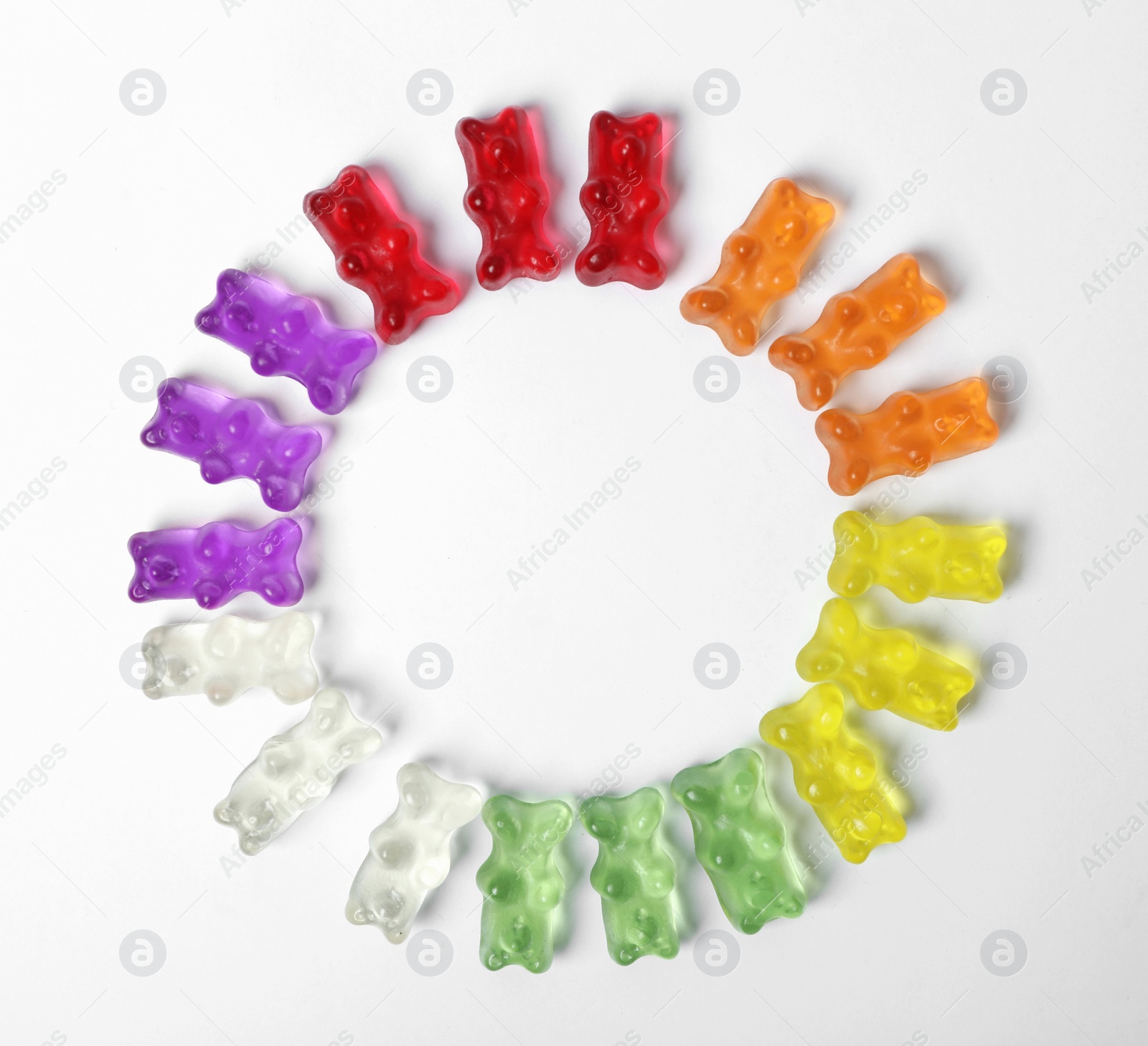 Photo of Circle of delicious color jelly bears on white background, top view