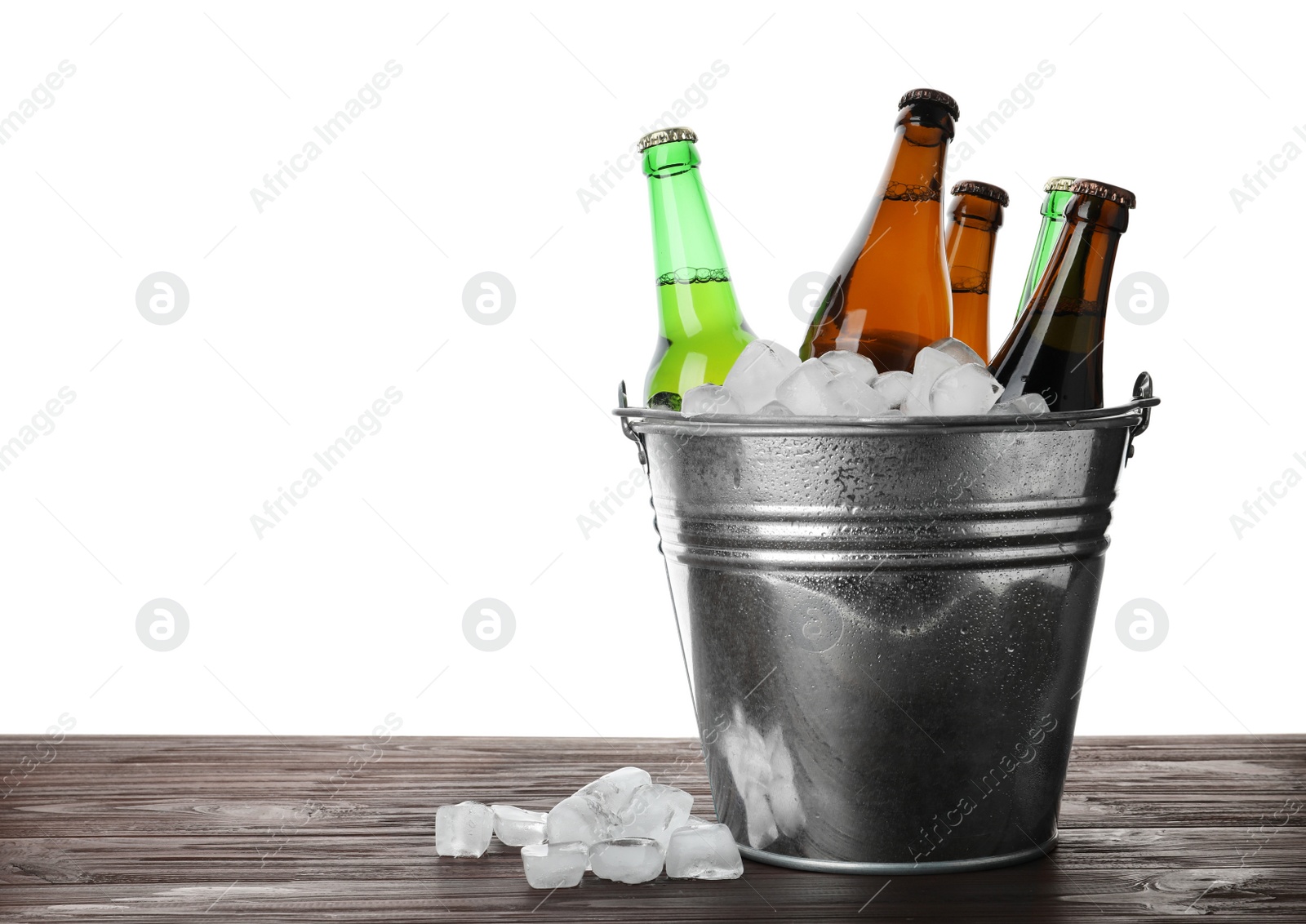 Photo of Metal bucket with bottles of beer and ice cubes on wooden table against white background. Space for text