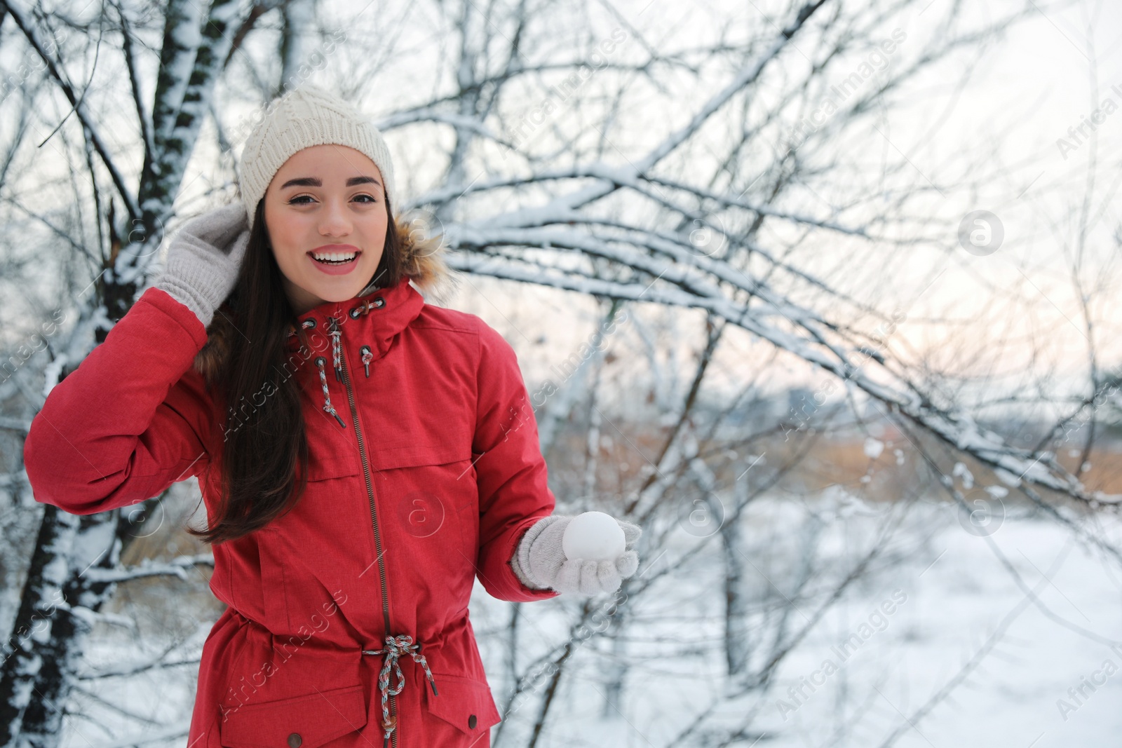 Photo of Young woman holding snowball outdoors on winter day. Space for text