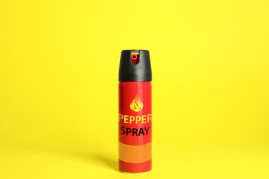Image of Bottle of gas pepper spray on yellow background